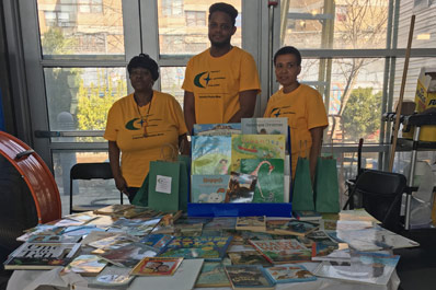 The team standing around table covered with books